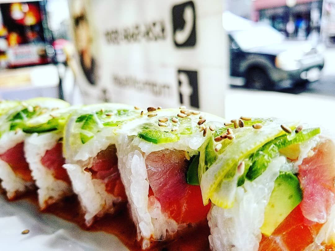 A close up of a row of sushi rolls on a table.