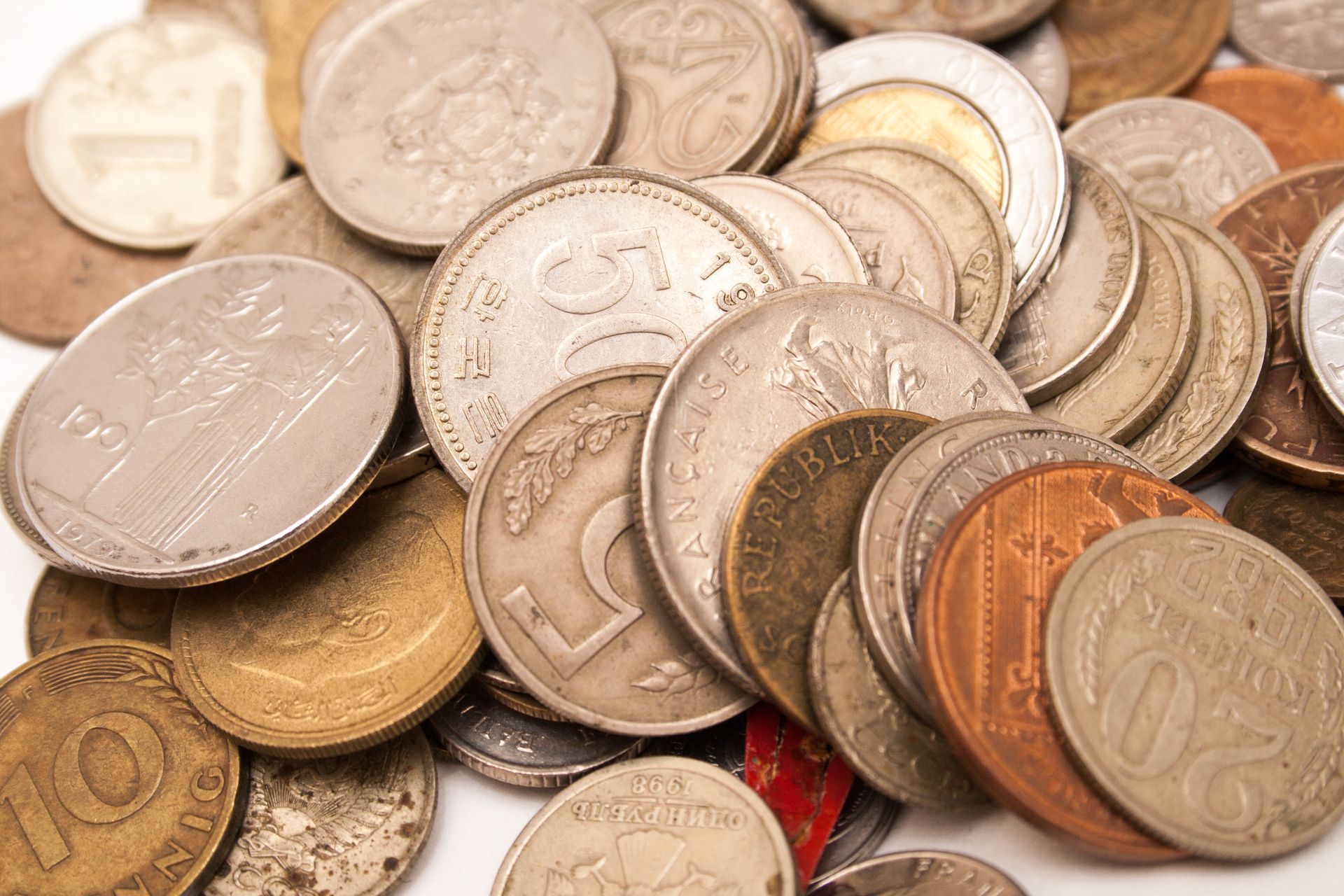 Pile of various coins, including silver, copper, and gold colors.