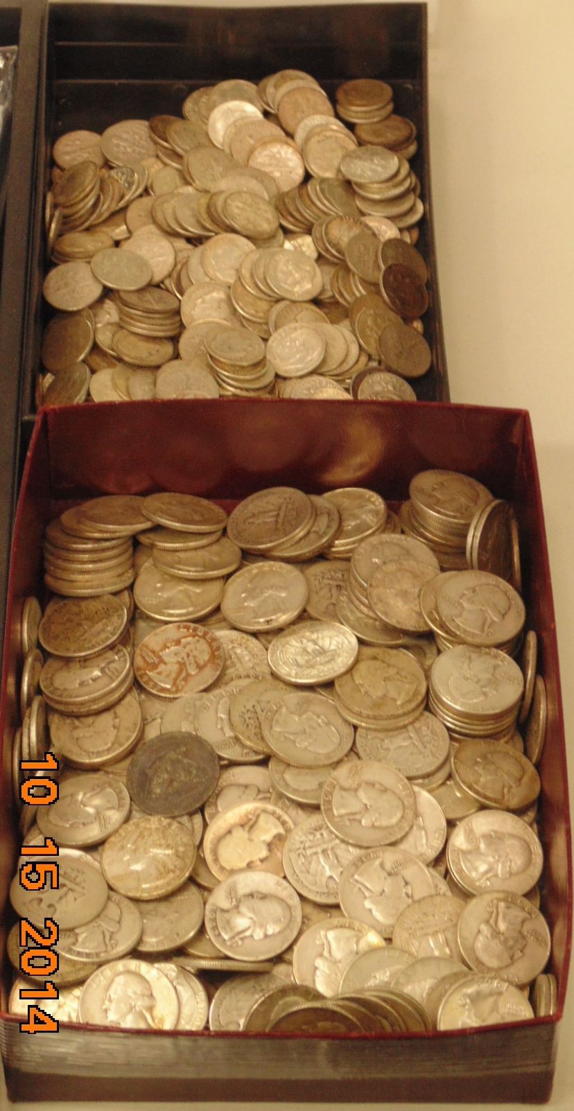 Two trays overflowing with silver coins.