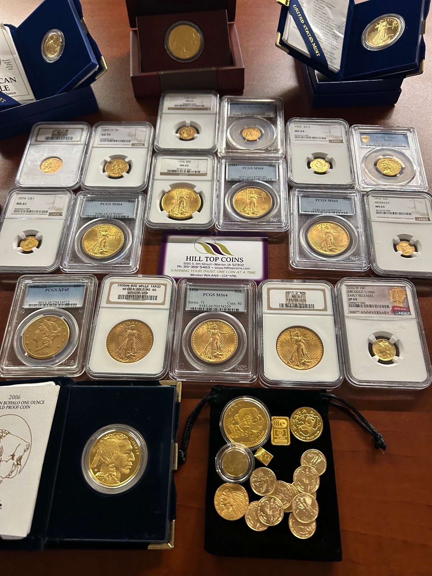 Arrangement of gold coins, some in protective cases, displayed on a wooden surface.