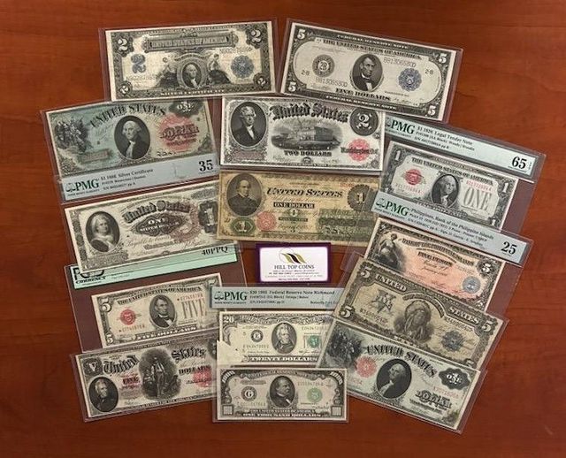 Collection of historical US paper currency in protective sleeves displayed on a wooden surface.