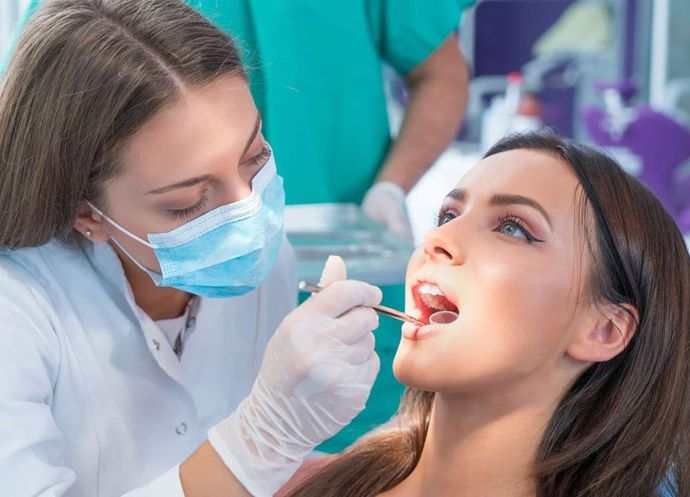 A woman is getting her teeth examined by a dentist.