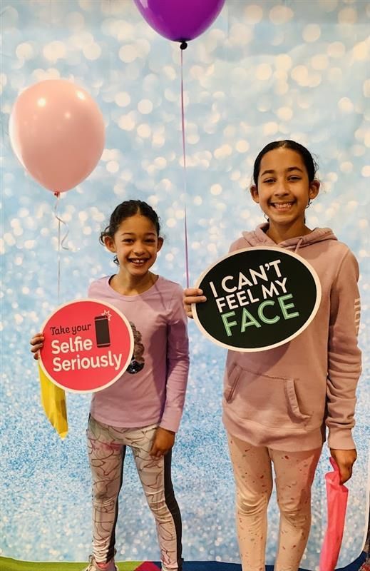 Two young girls are holding signs