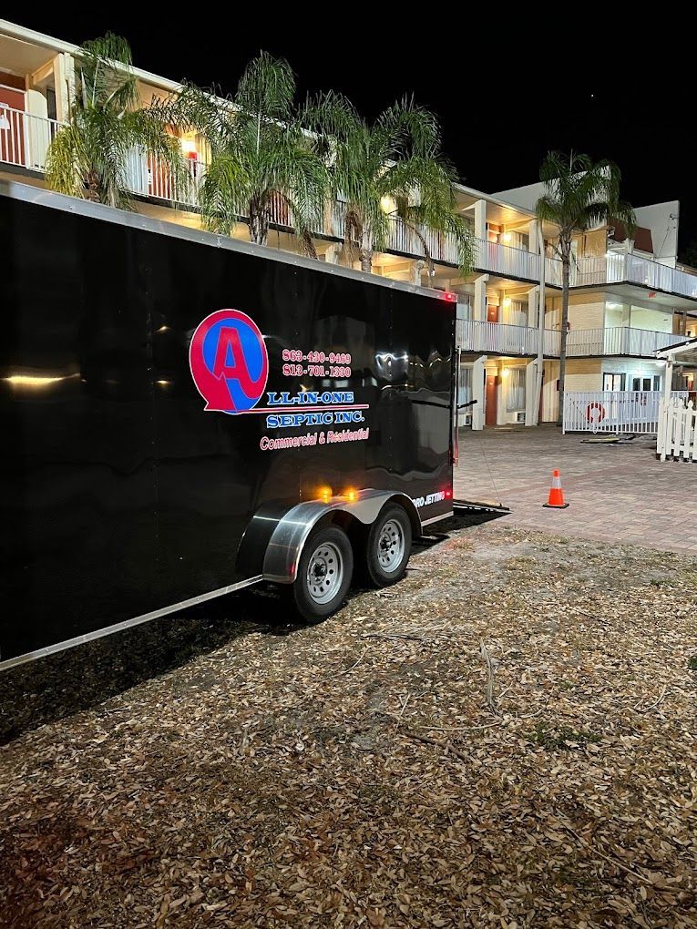 A black trailer is parked in front of a building at night.