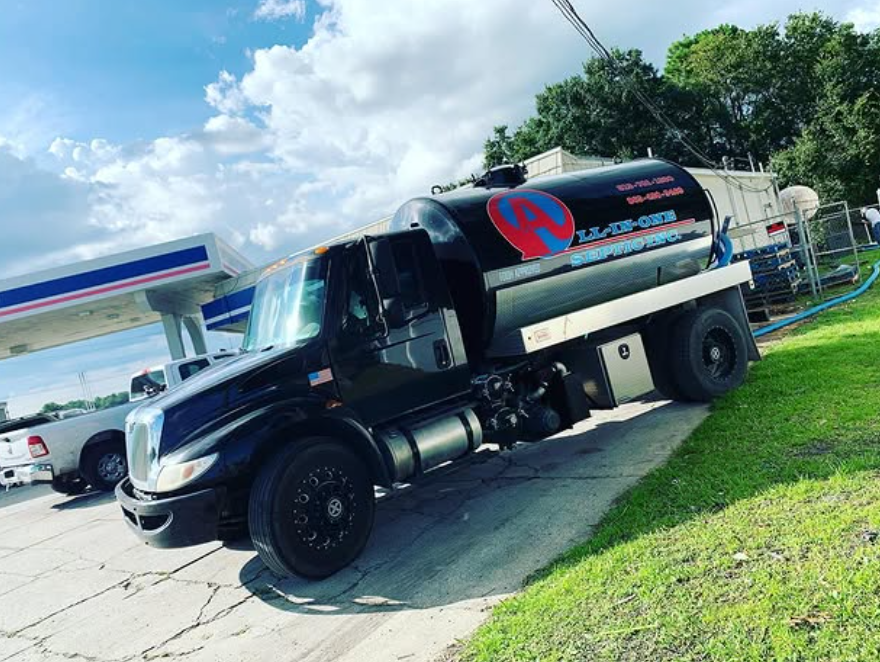 A black truck is parked in front of a gas station.