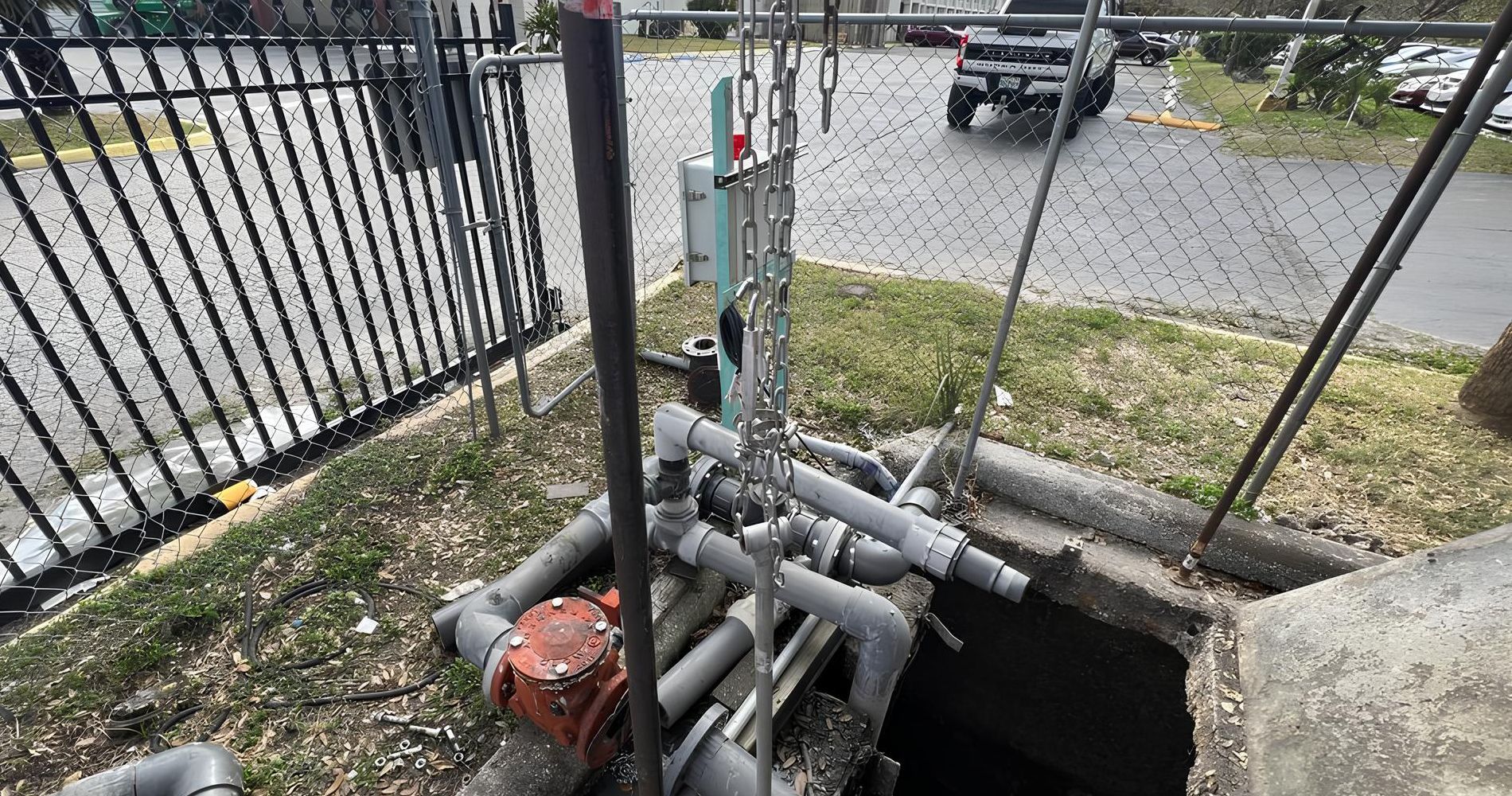 A manhole cover with a bunch of pipes coming out of it.