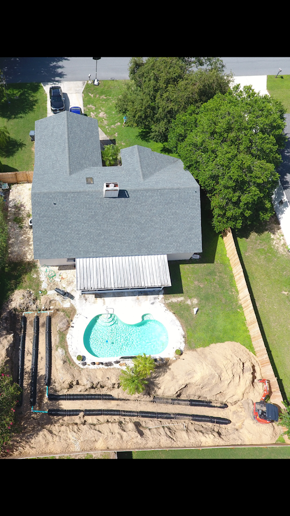 An aerial view of a house with a pool in the backyard.