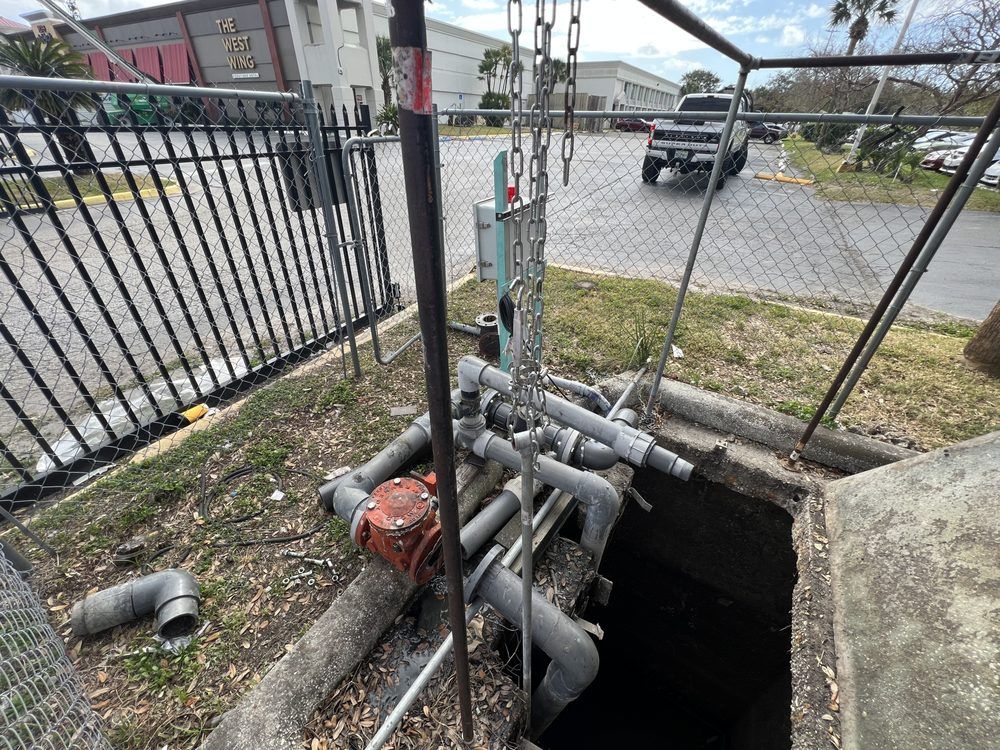 A manhole cover with a bunch of pipes coming out of it.