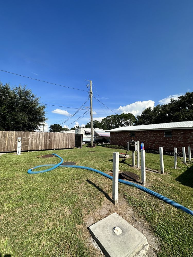 A hose is connected to a septic tank in a backyard.