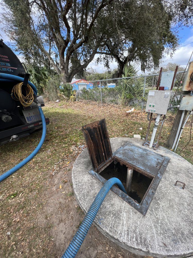 A septic tank is being pumped with a hose.