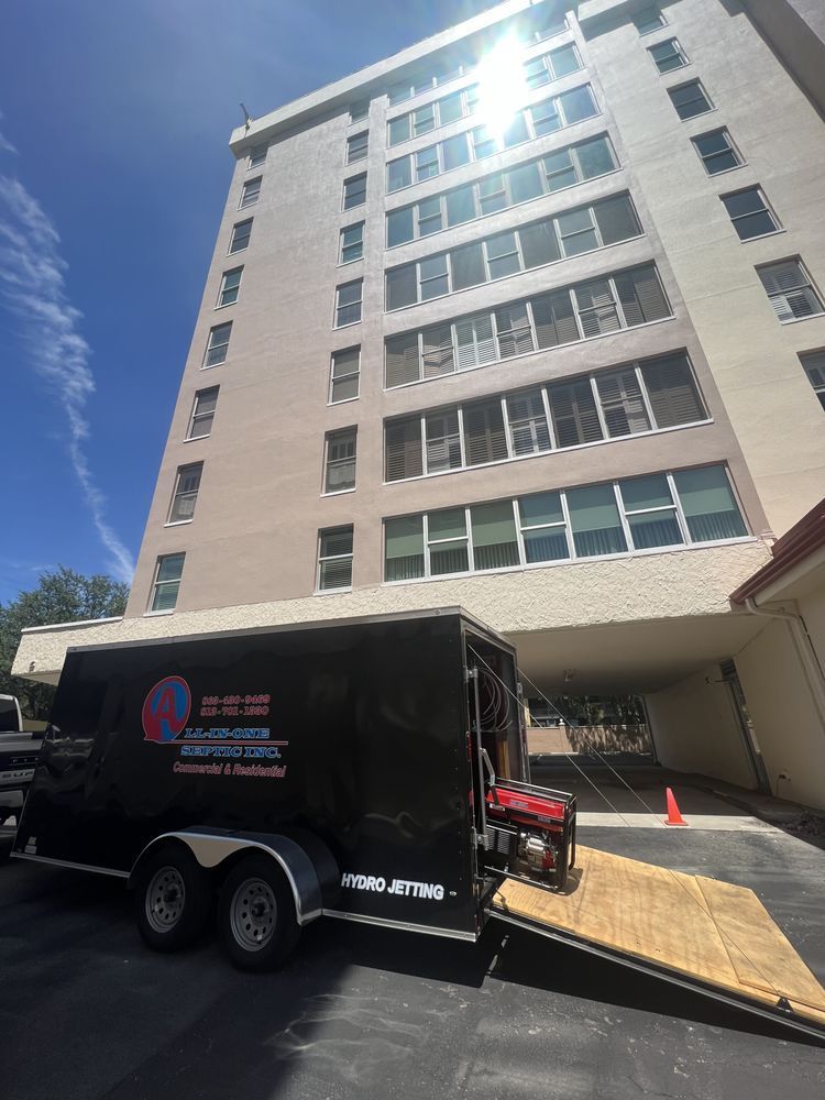 A black trailer is parked in front of a tall building.