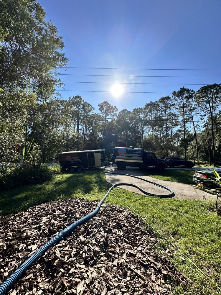 A hose is connected to a truck in a yard.