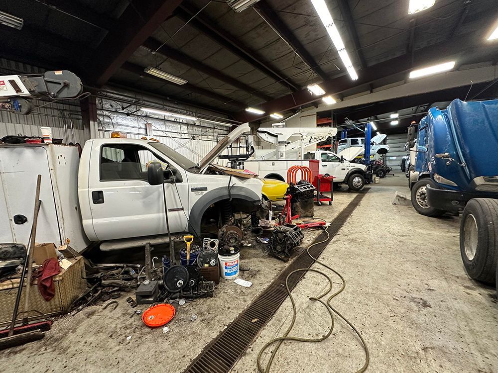A truck is sitting in a garage with other trucks