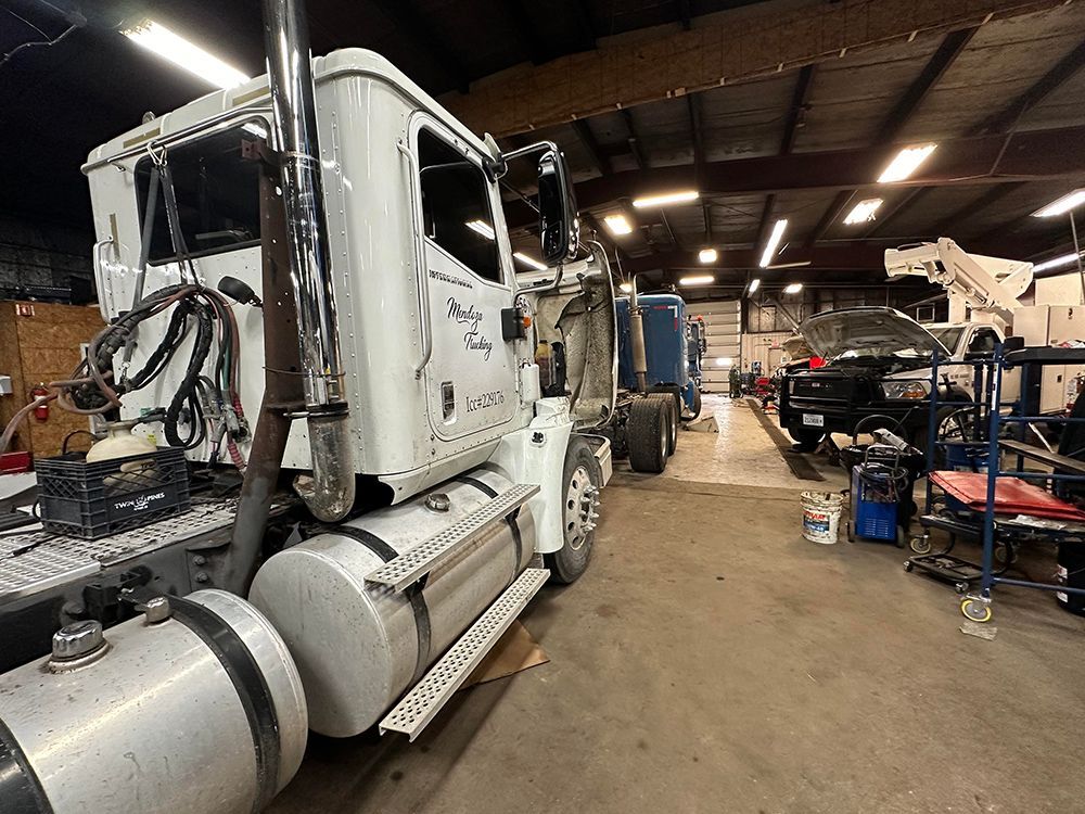 A white semi truck is parked in a garage