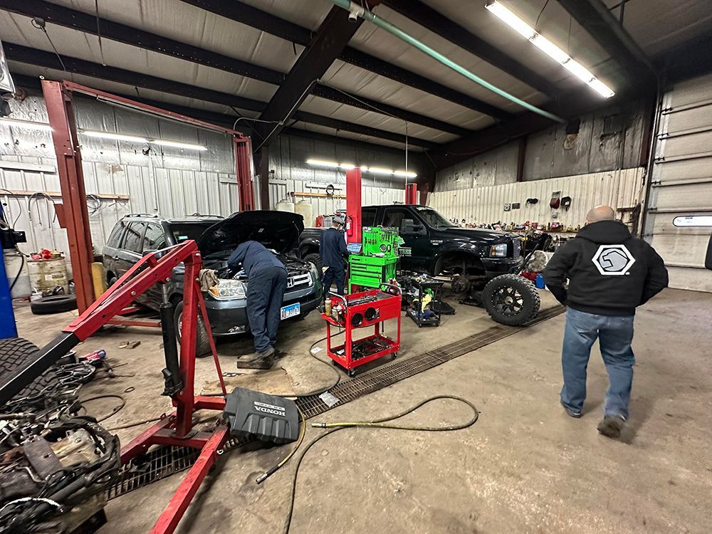 A group of men are working on a car in a garage