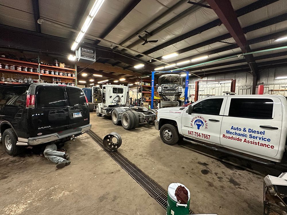 A man is changing a tire on a truck in a garage