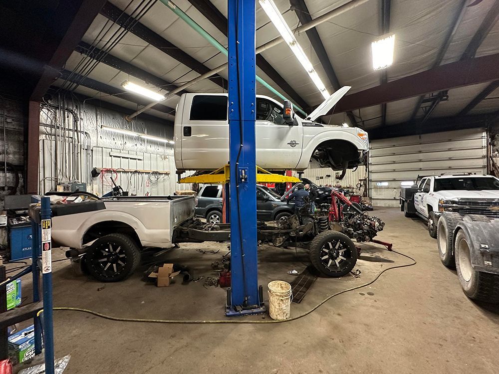 A truck is sitting on a lift in a garage.