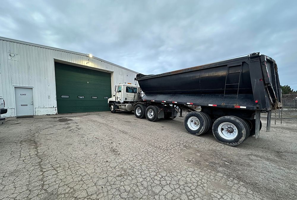 A dump truck is parked in front of a building