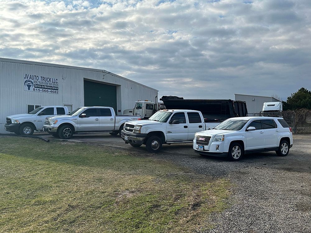 A row of white trucks parked in front of a building