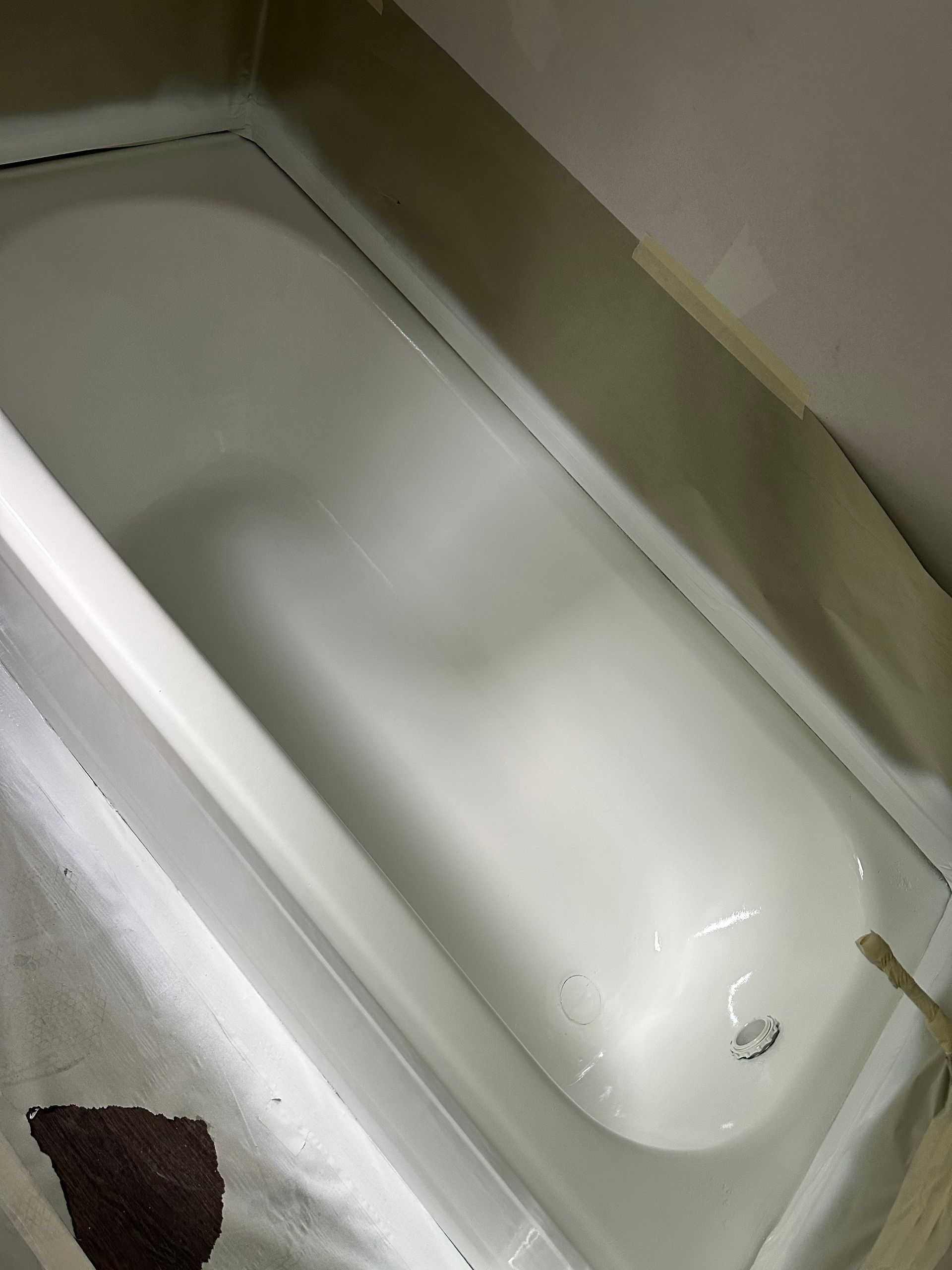 Empty white bathtub with a small brown cloth or sponge in the corner