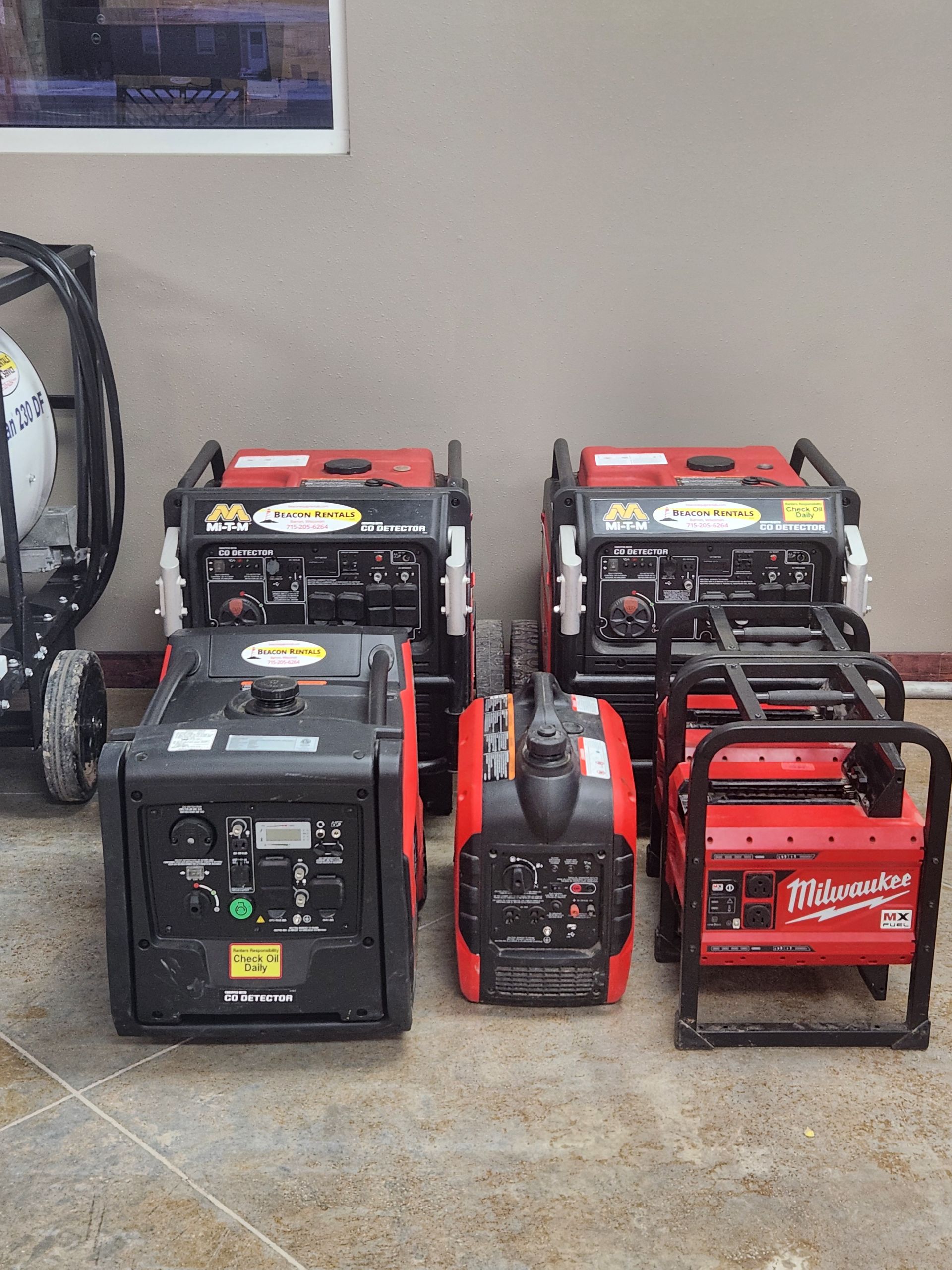 Several red and black portable generators displayed indoors.