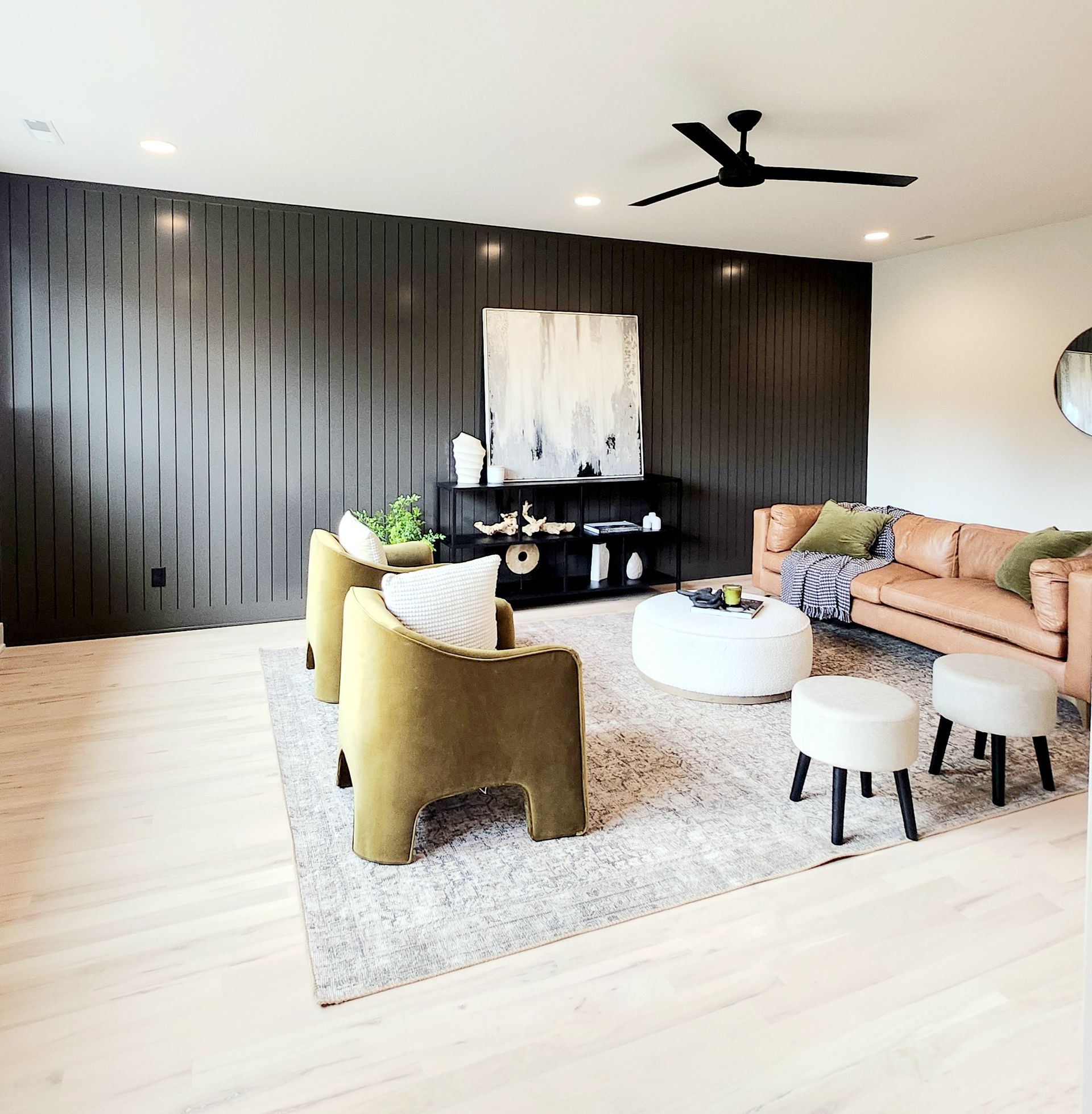 A living room with a couch and chairs and a ceiling fan