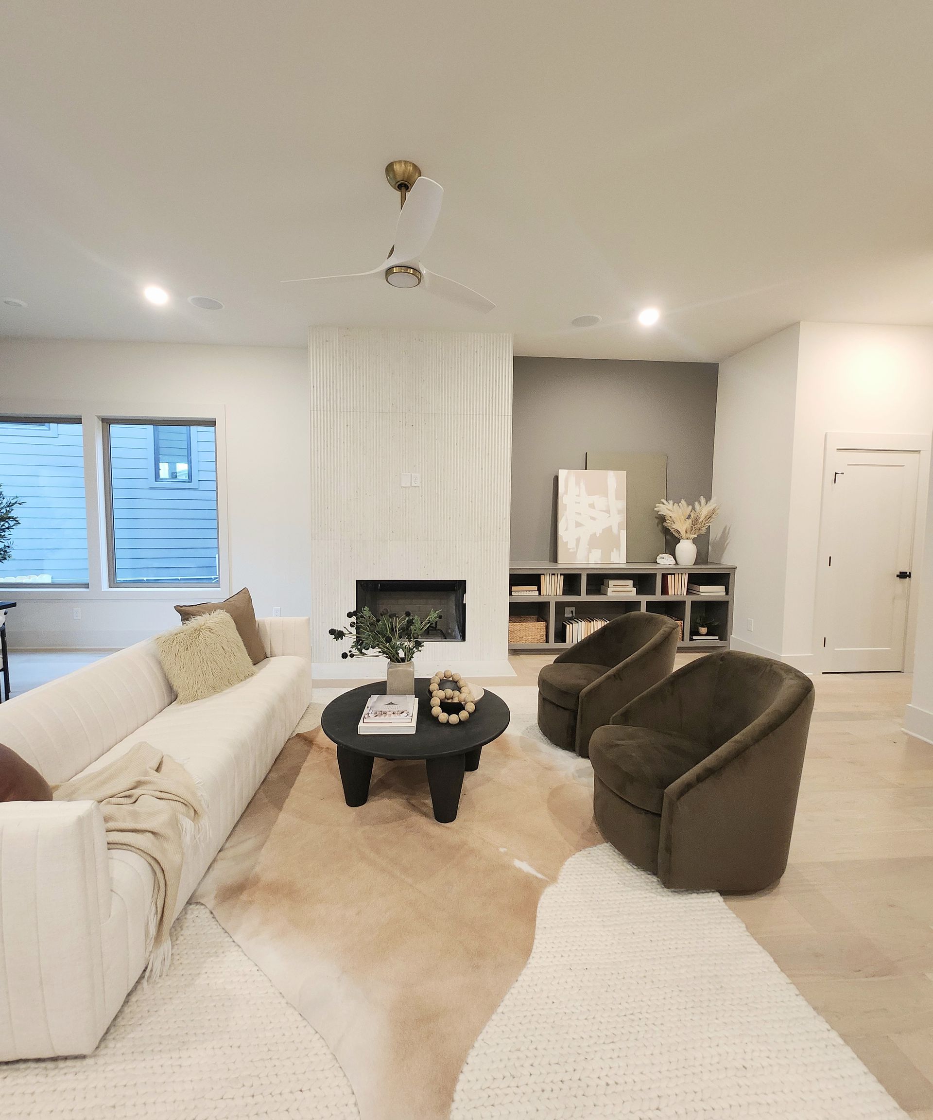 A living room with a couch , chairs , coffee table and fireplace.