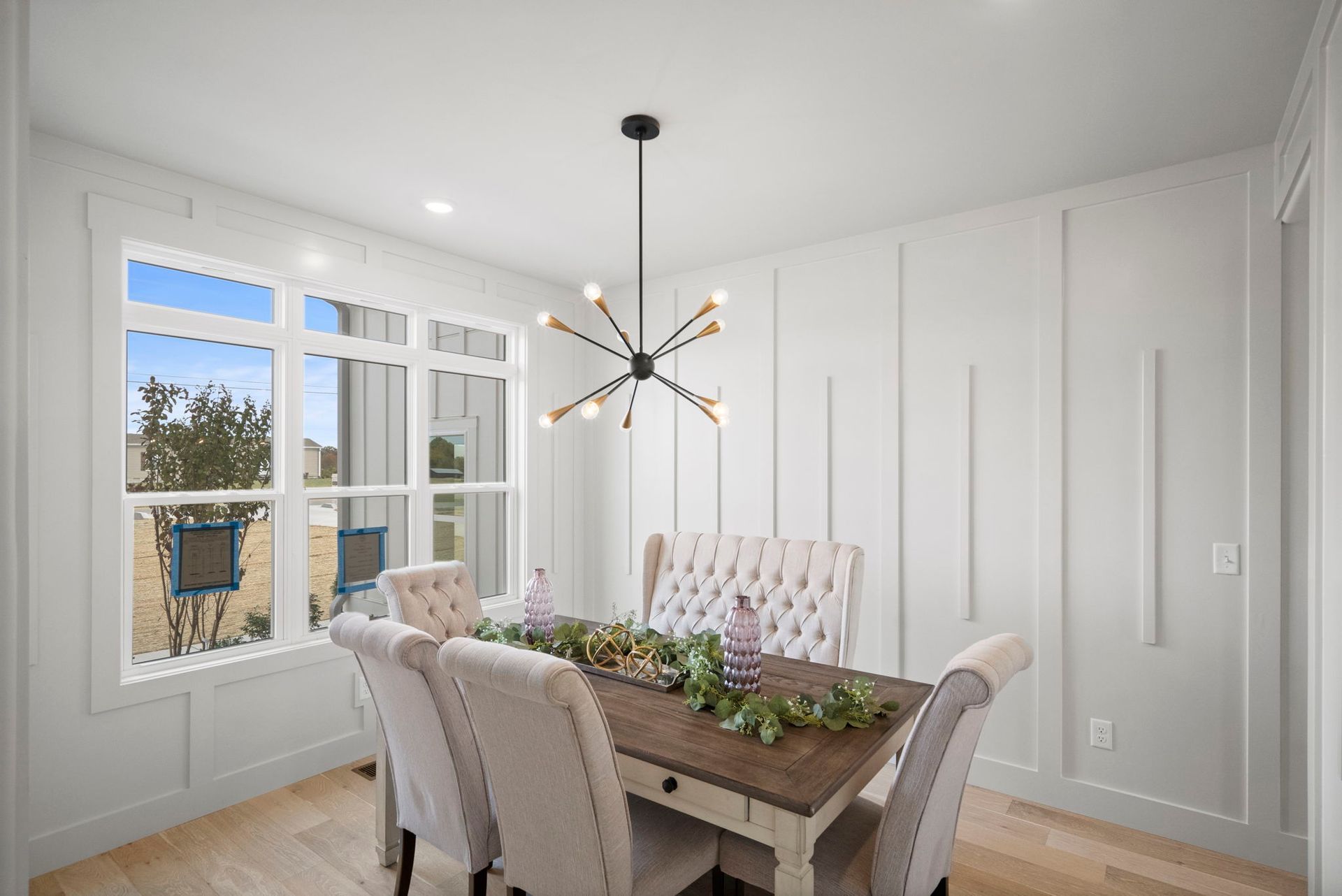 A dining room with a table and chairs and a chandelier.