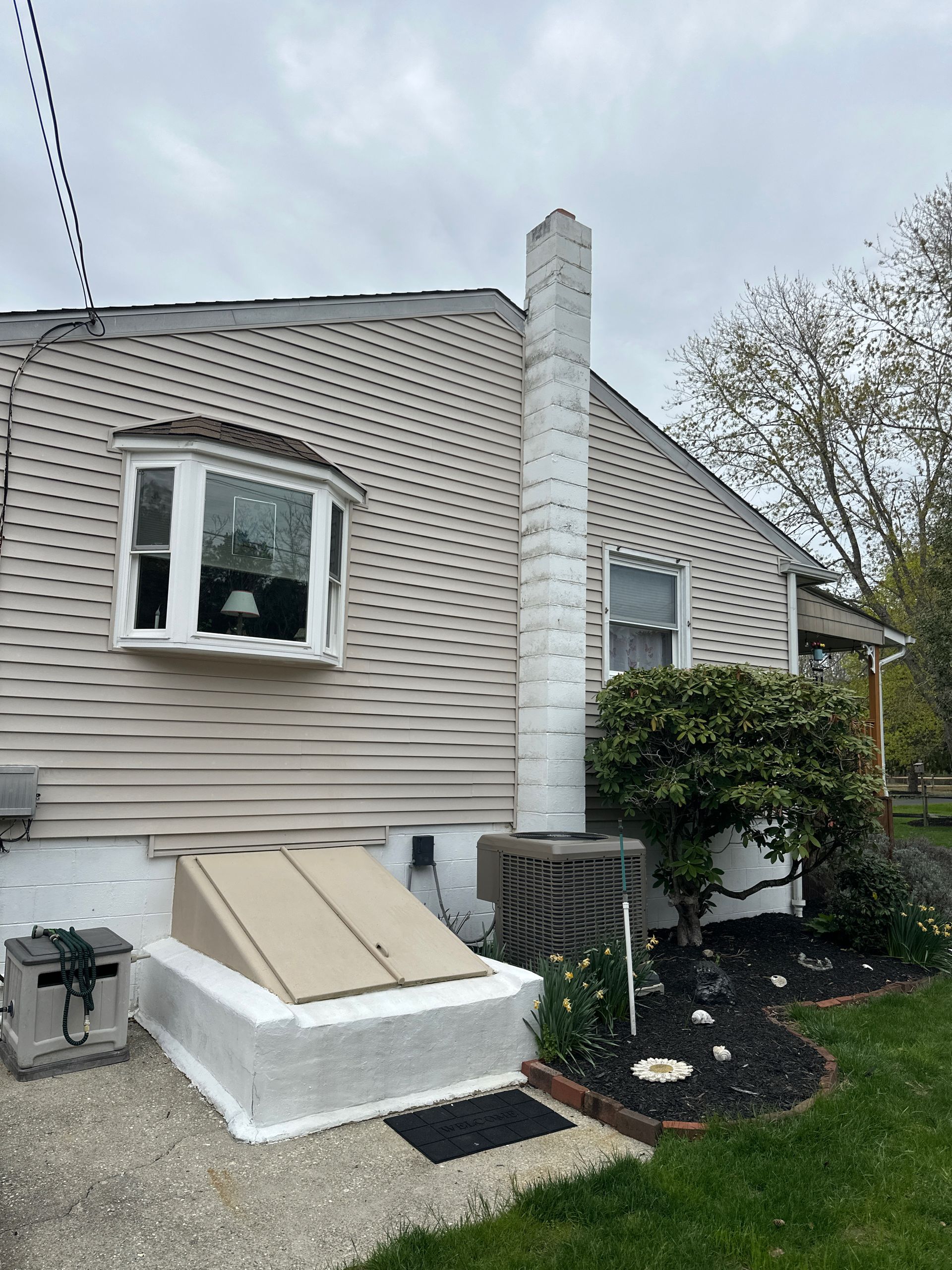 The back of a house with a chimney and a window.
