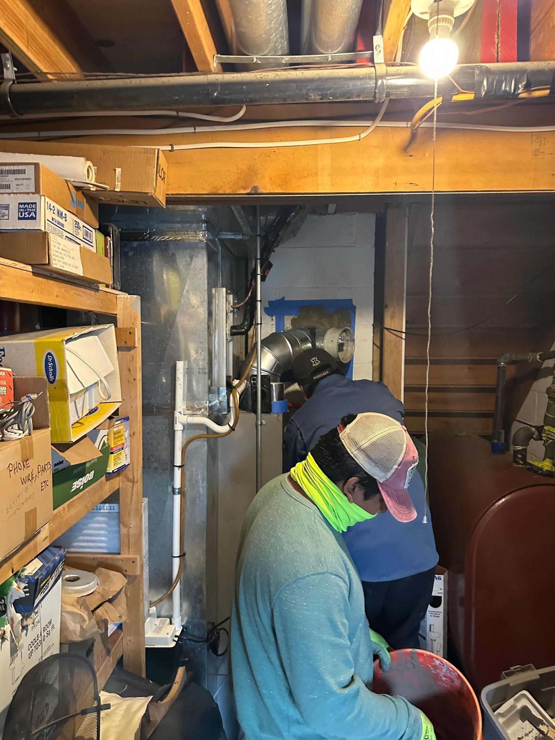 A man wearing a mask is working in a basement.