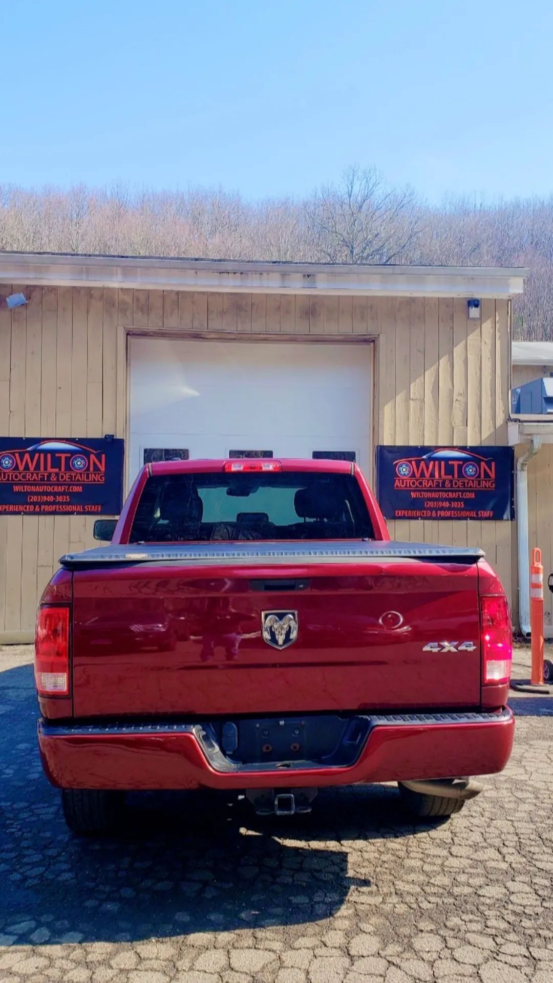 A red truck is parked in front of a building.