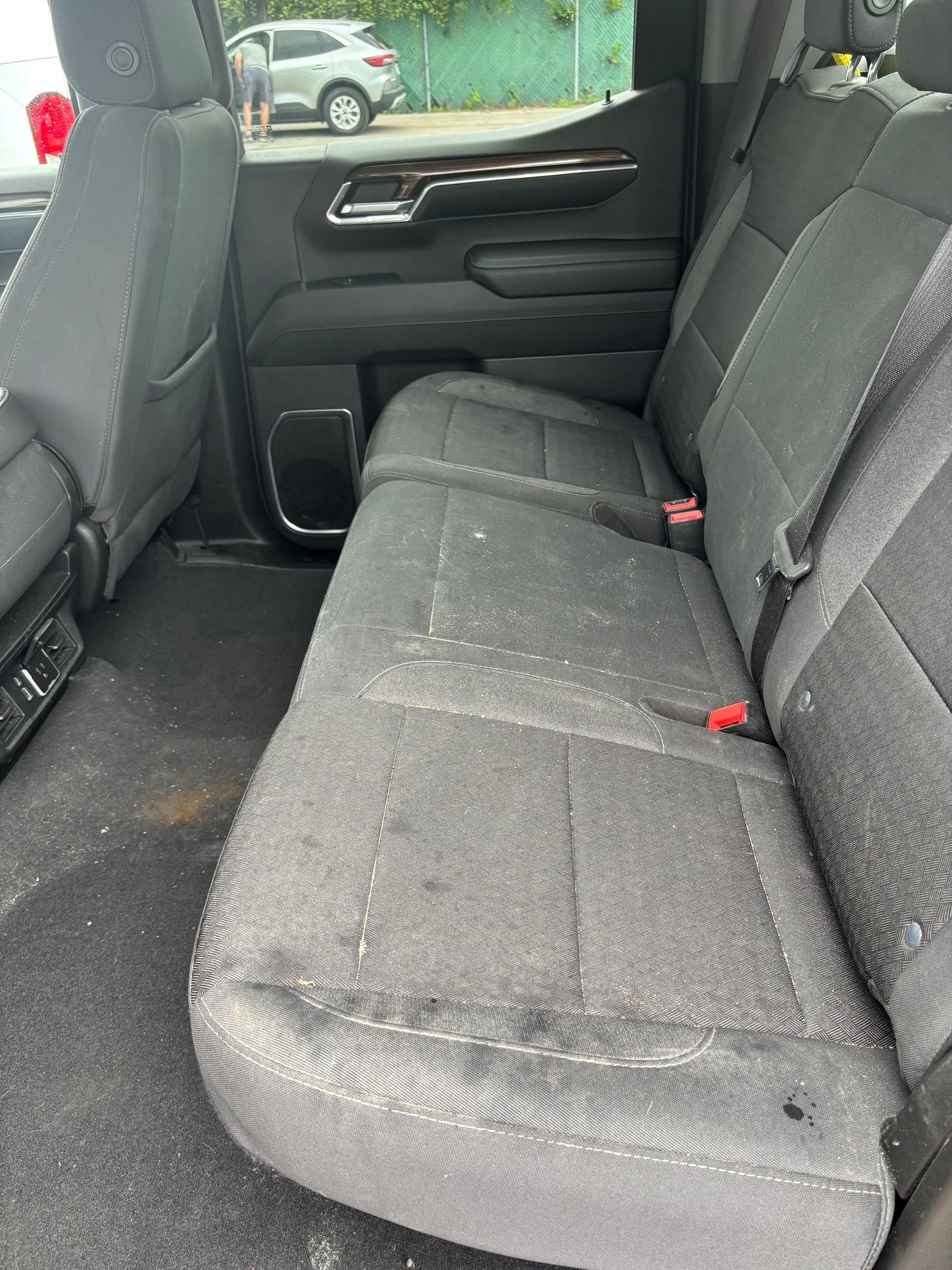 Car interior with black fabric back seat and door panel, showing the rear passenger area