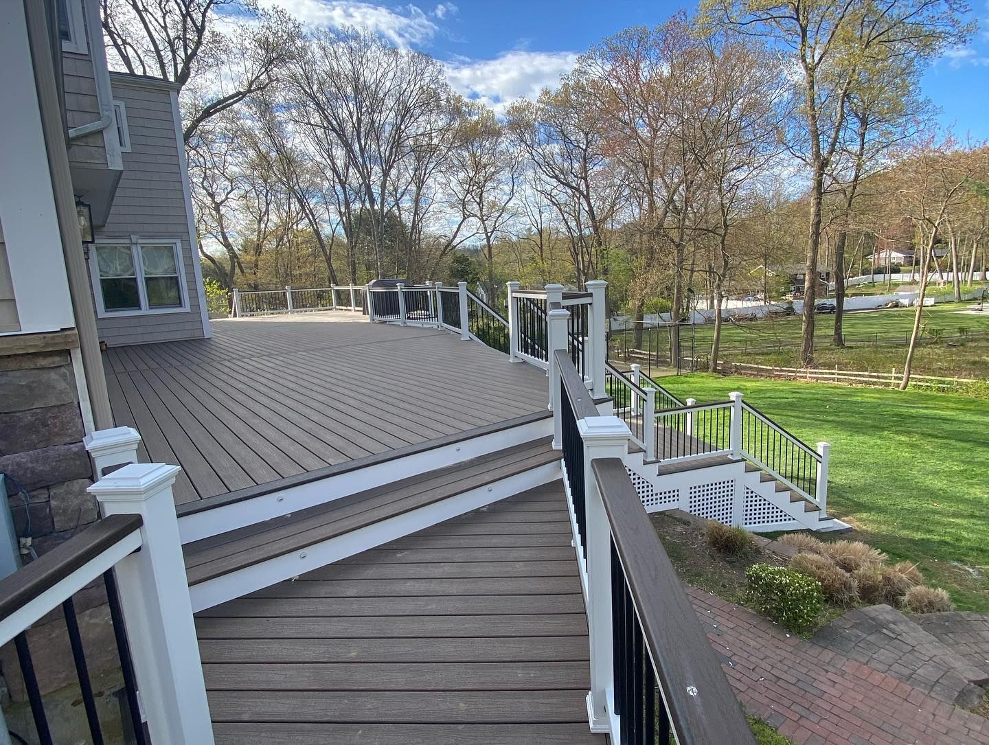 A deck with stairs leading up to it and trees in the background.