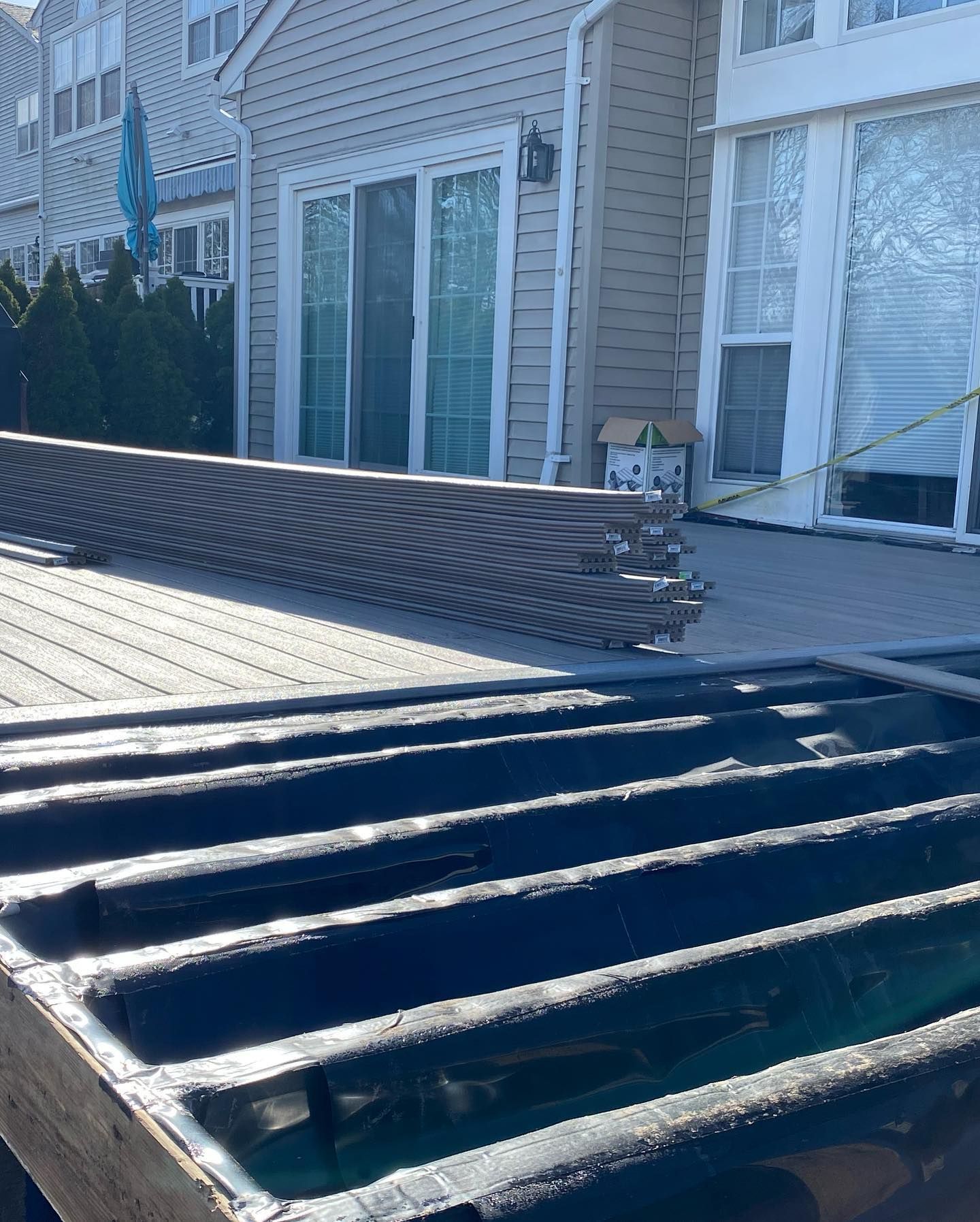 A wooden deck is being built in front of a house.
