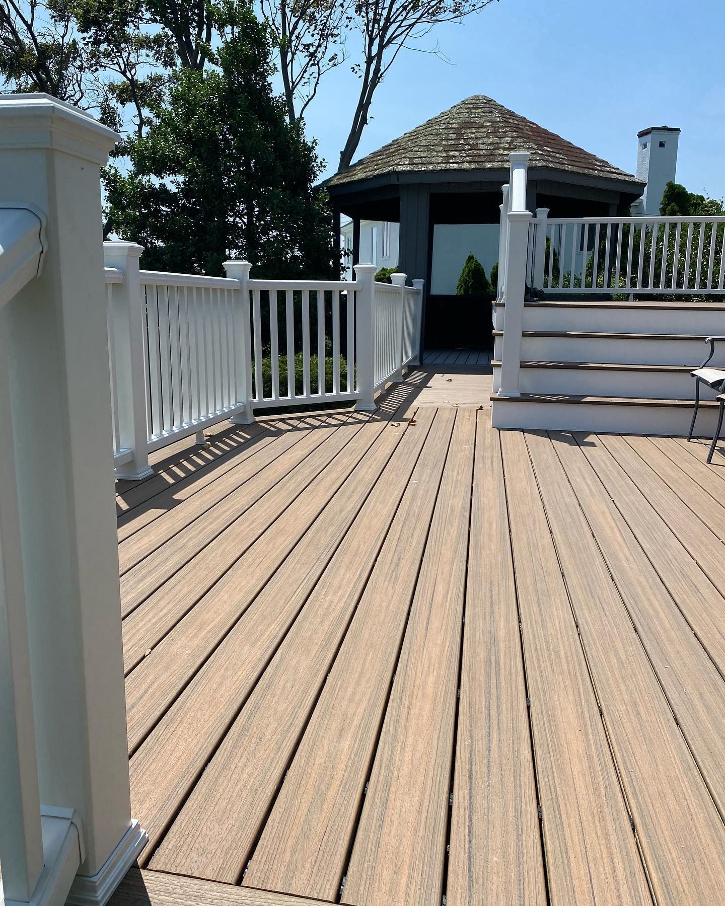 A wooden deck with a gazebo in the background.