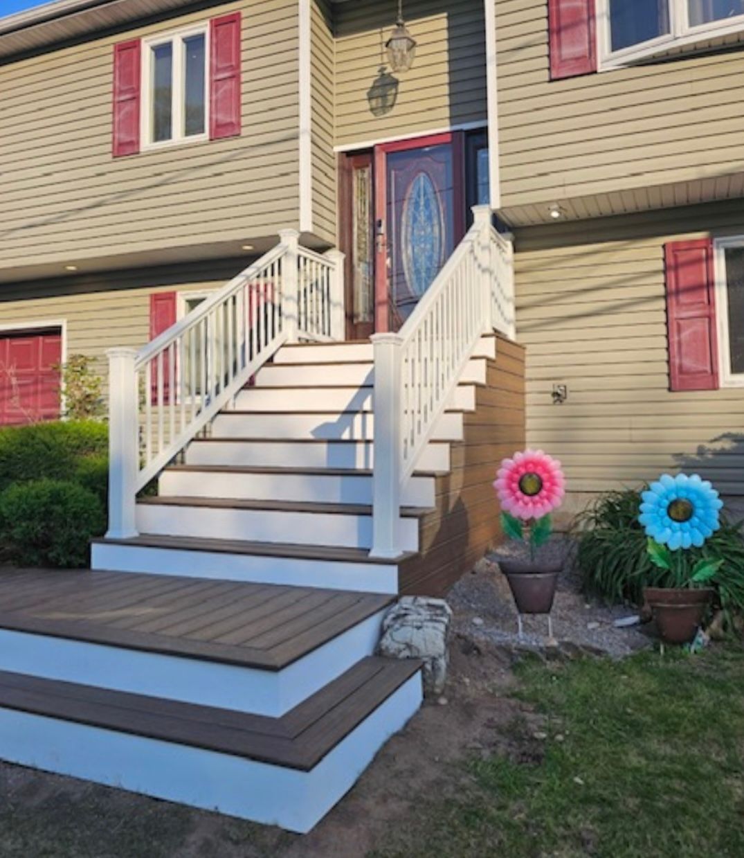 A house with stairs and flowers in front of it