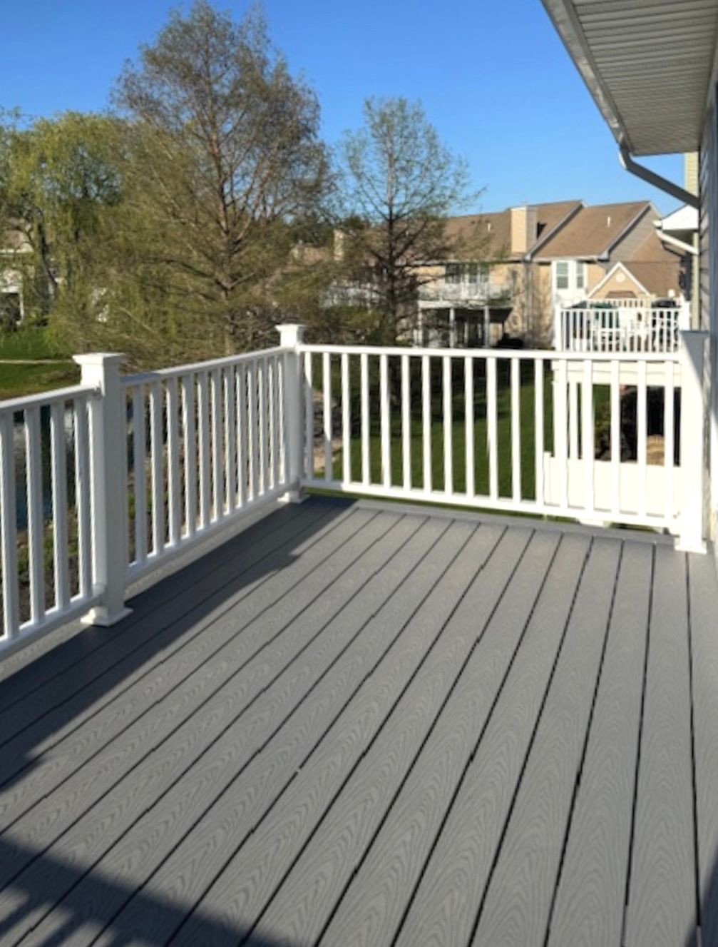 A balcony with a white railing and a gray deck.