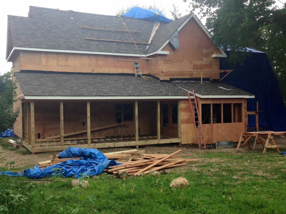 A large house with a lot of windows is sitting in the middle of a grassy field.