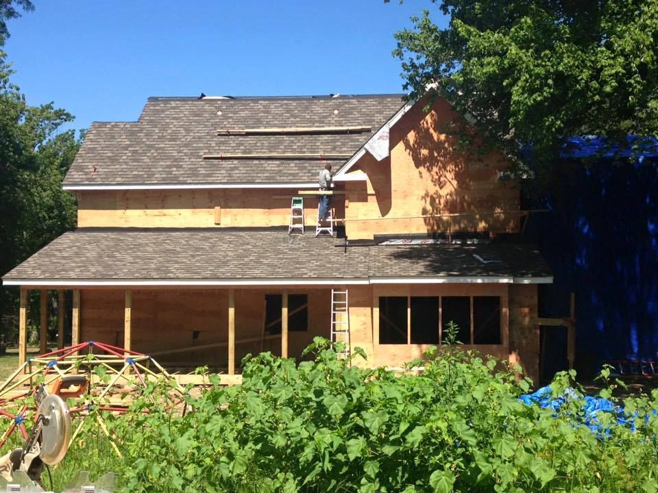 A house that is being built with a ladder on the roof