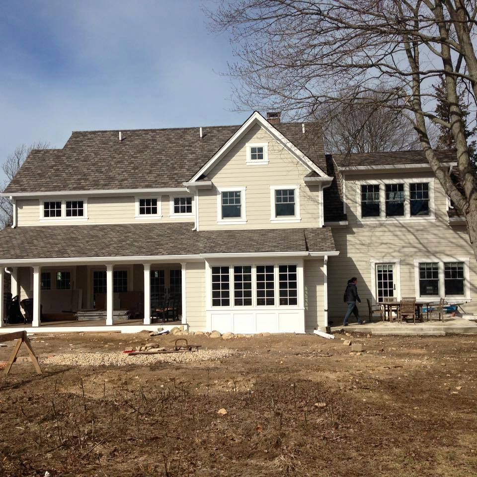 A house that is being built with a ladder on the roof