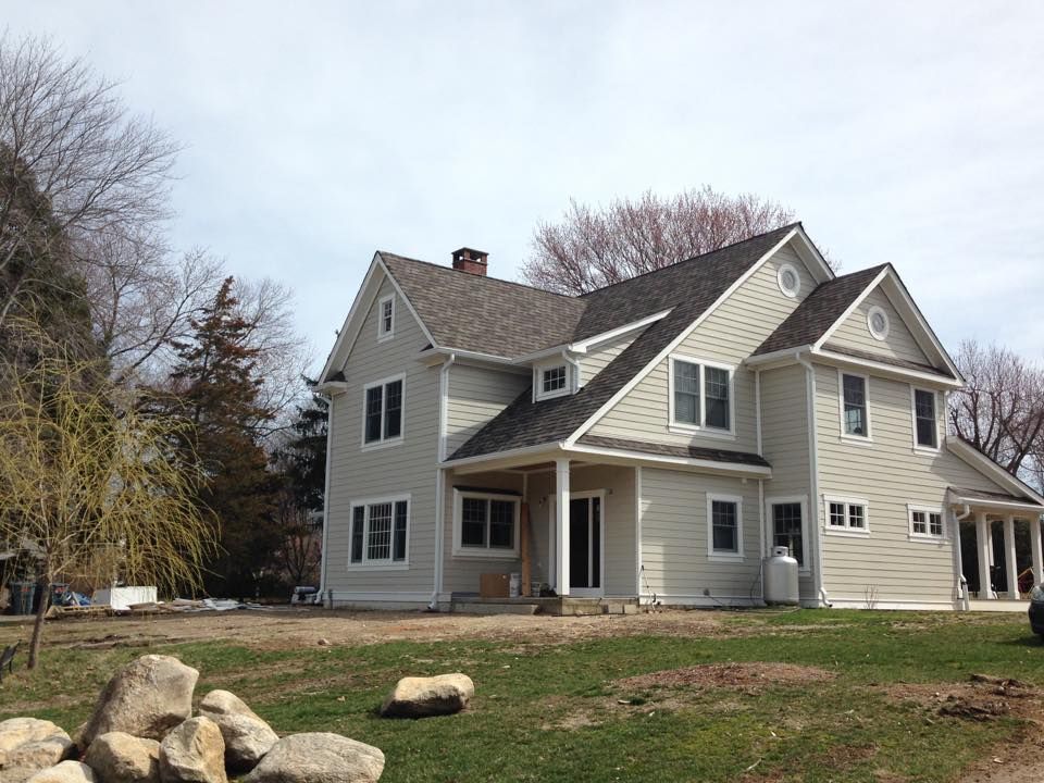 A large white house with a gray roof.