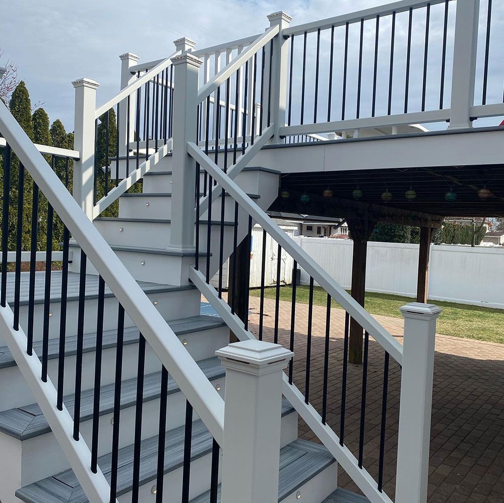 A white deck with stairs and a black railing