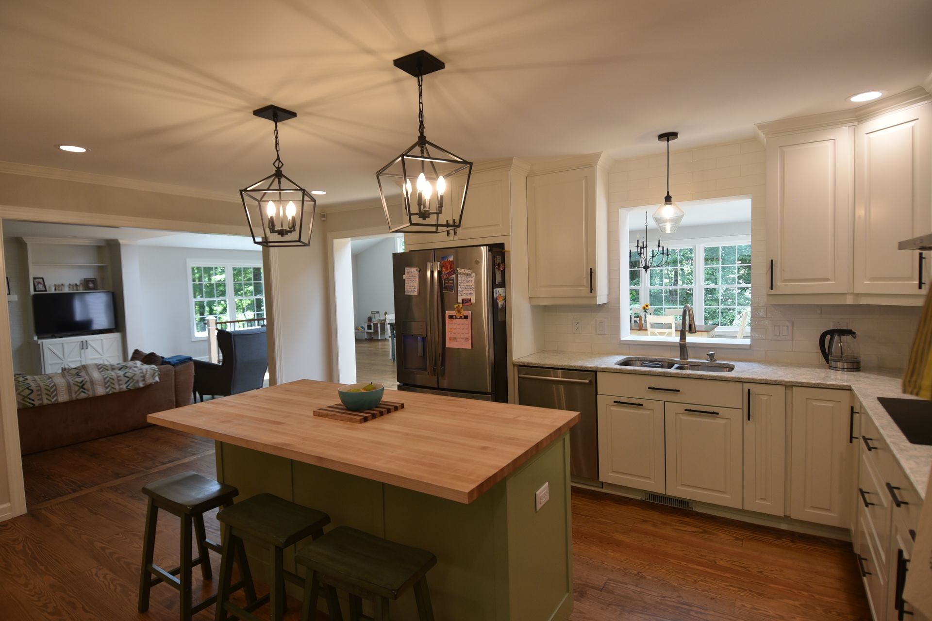 Kitchen with white cabinets, wood island, and stainless steel appliances.