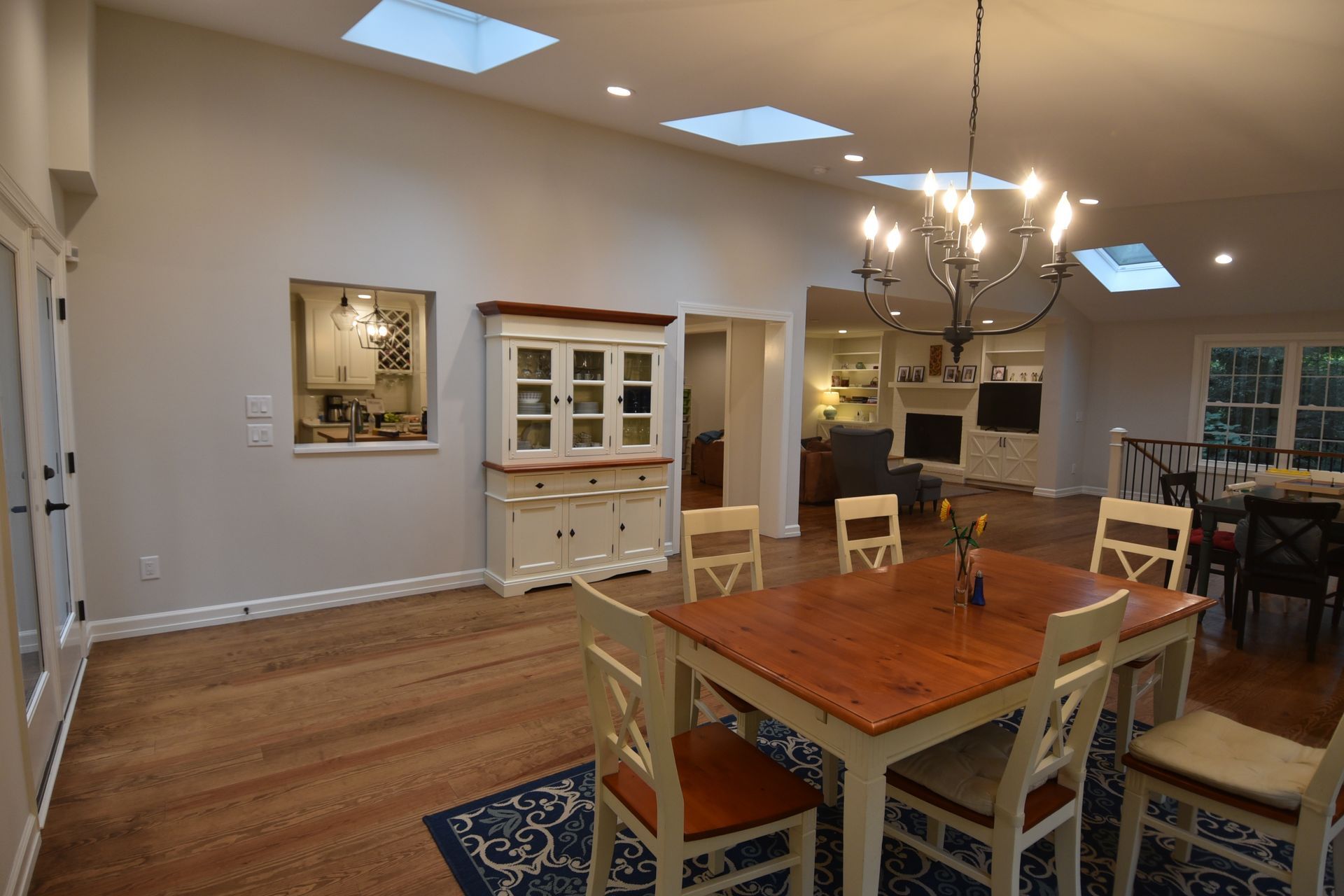 Dining room with a wooden table and chairs, hutch, and skylights.