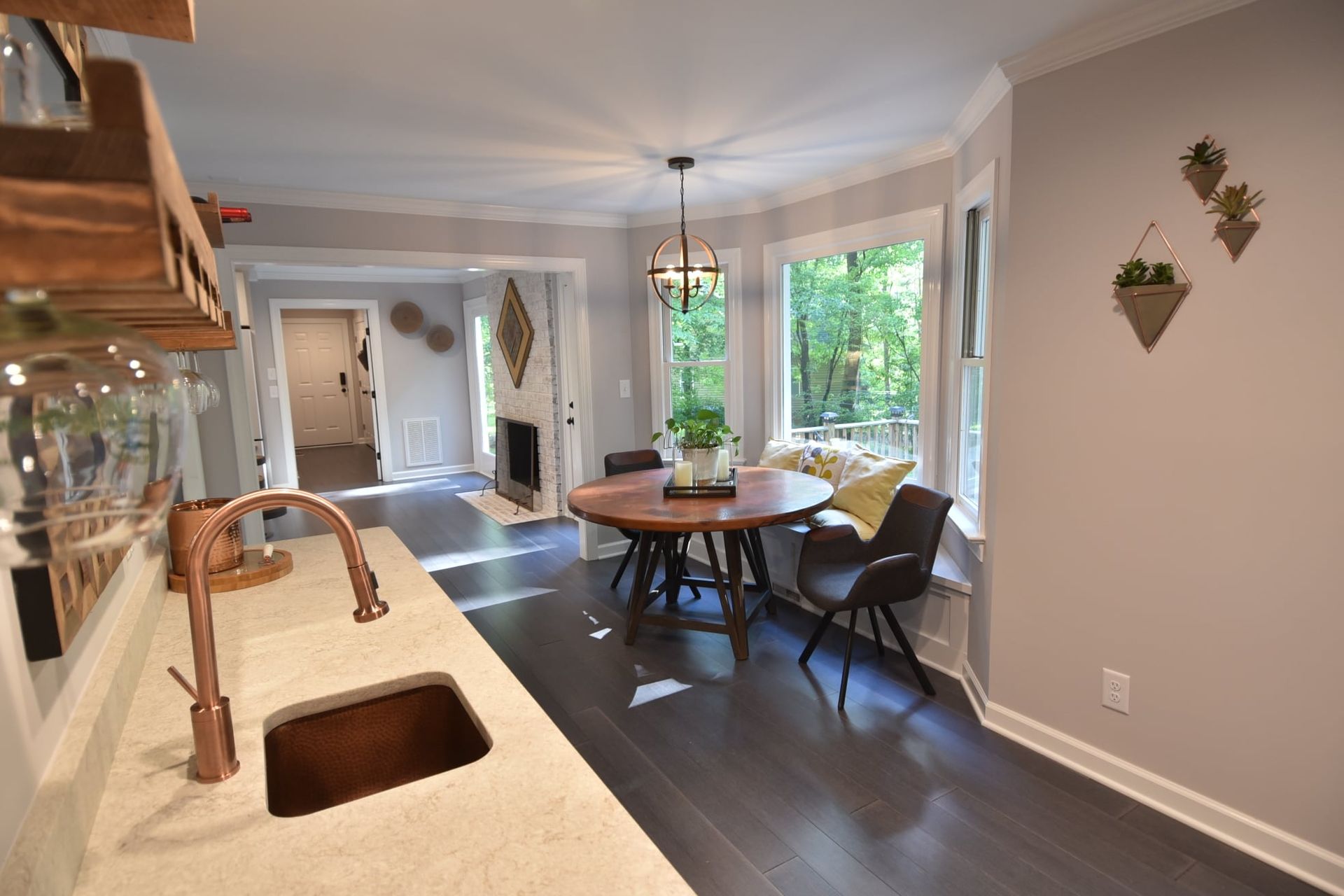 A kitchen with a sink , table and chairs.