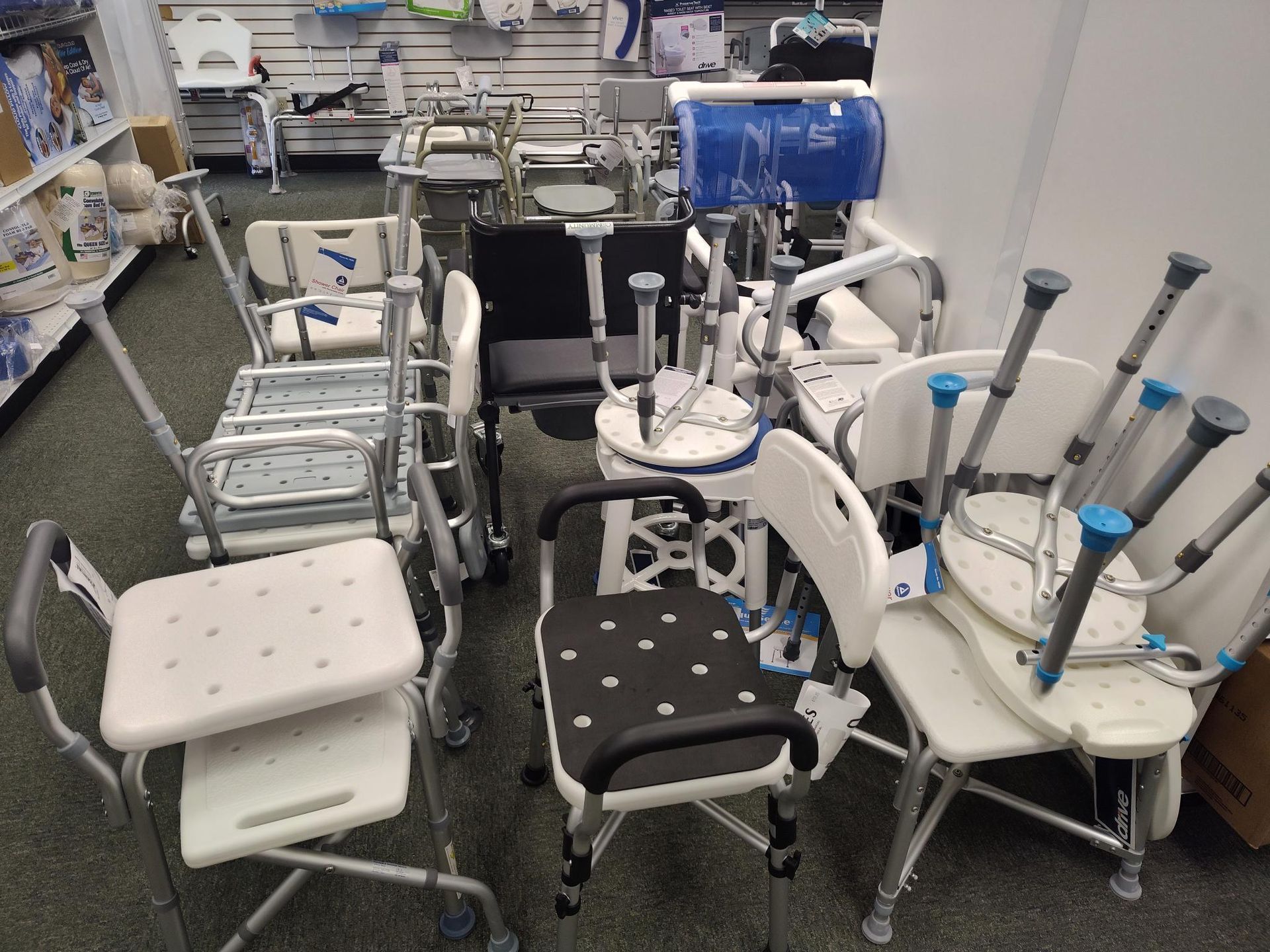 Medical supply store, various shower chairs and walkers on display.