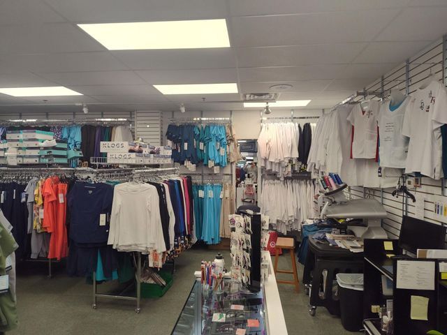 Clothing store interior with racks of colorful shirts and accessories.