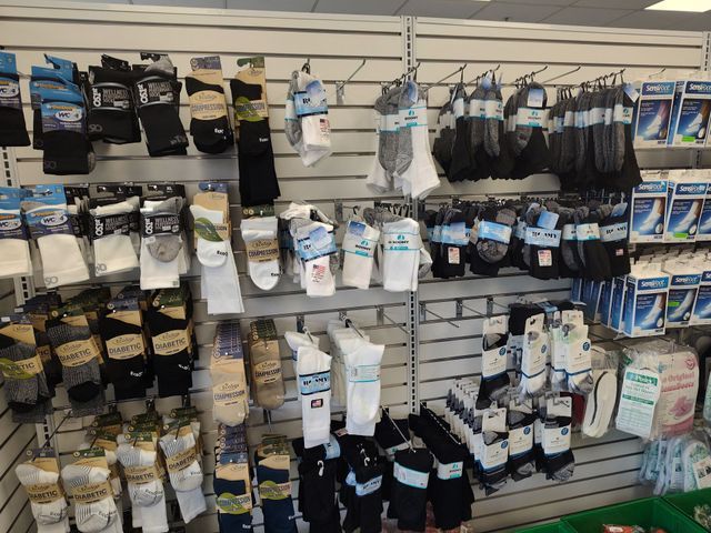 A display of various socks in a retail setting, organized on wall shelves.