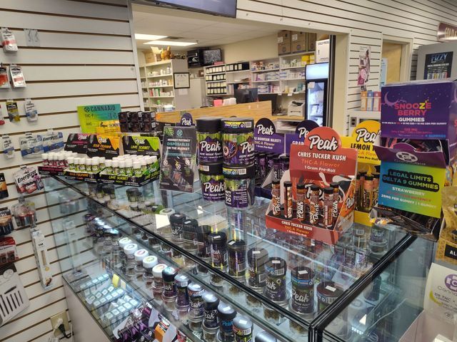 Interior of a store, displaying various supplement products on shelves and a glass counter.