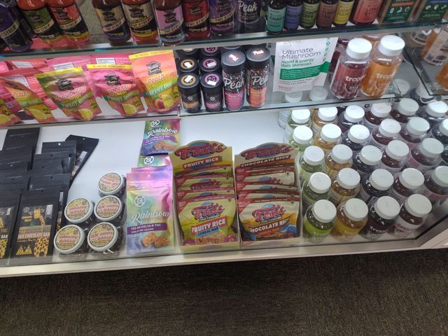 Shelves of colorful snacks, drinks, and supplements in a retail store display.